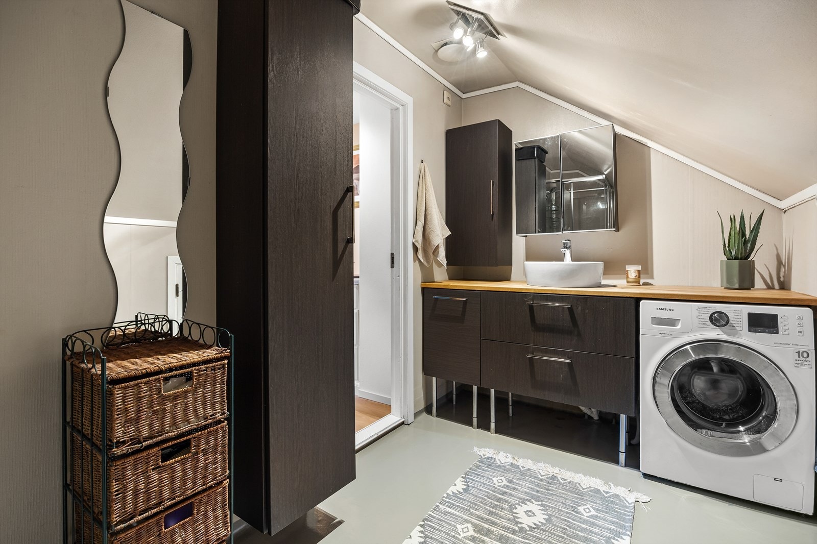Badet har dusjkabinett, toalett og skålservant med innredning fra 2021. Opplegg for vaskemaskin under benk. Galleribilde