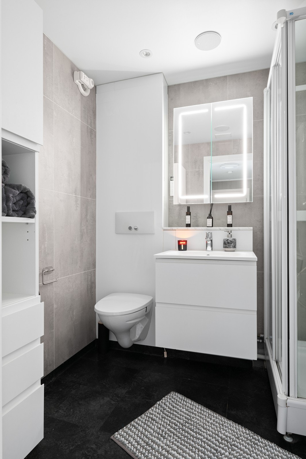 Badet har blant annet downlights og høyttaleranlegg i nedforet himling, baderomsplater som er montert på eksisterende vegg og selvklebende vinylflis er lagt på eksisterende gulvbelegg Galleribilde
