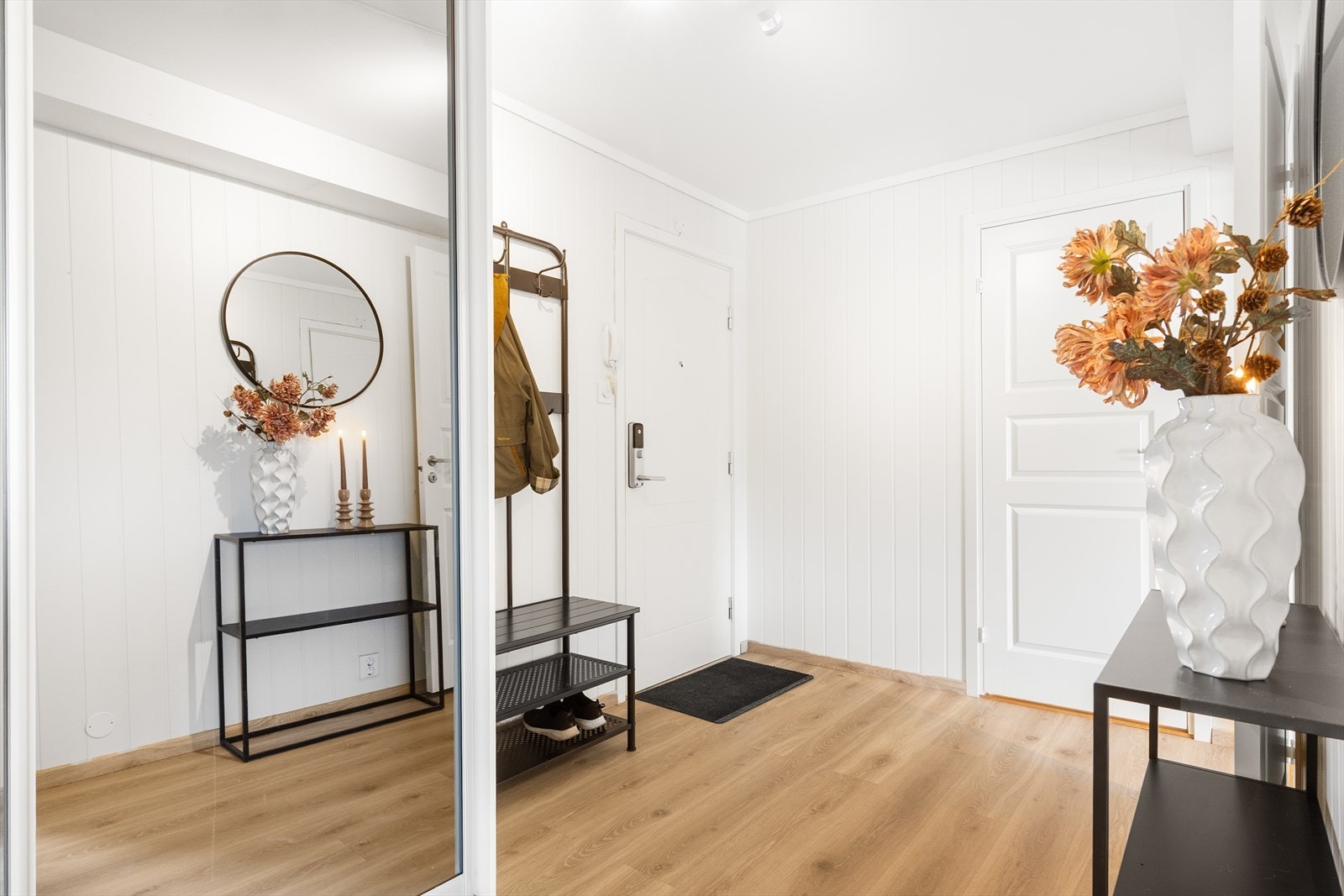 Leiligheten har en romslig entré med lyse overflater og praktisk skyvedørsgarderobe for oppbevaring av sko- og yttertøy. Galleribilde