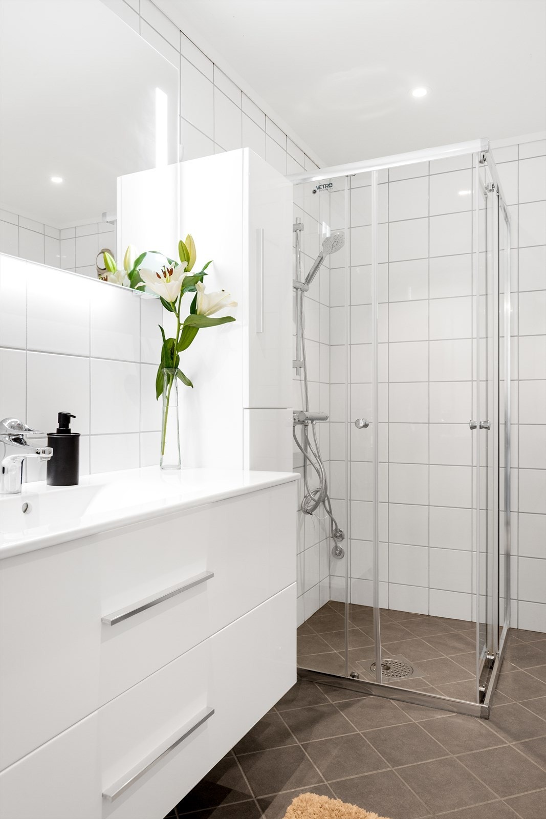 Badet har vegghengt toalett med innebygd sisterne, dusjnisje med dører i herdet glass og opplegg for vaskemaskin. Galleribilde