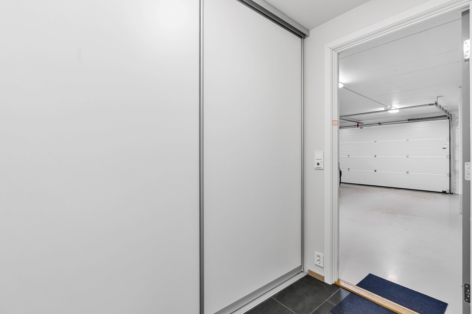 Privat entrè med skyvedørsgarderobe og adkomst til felles garasjeanlegg Galleribilde
