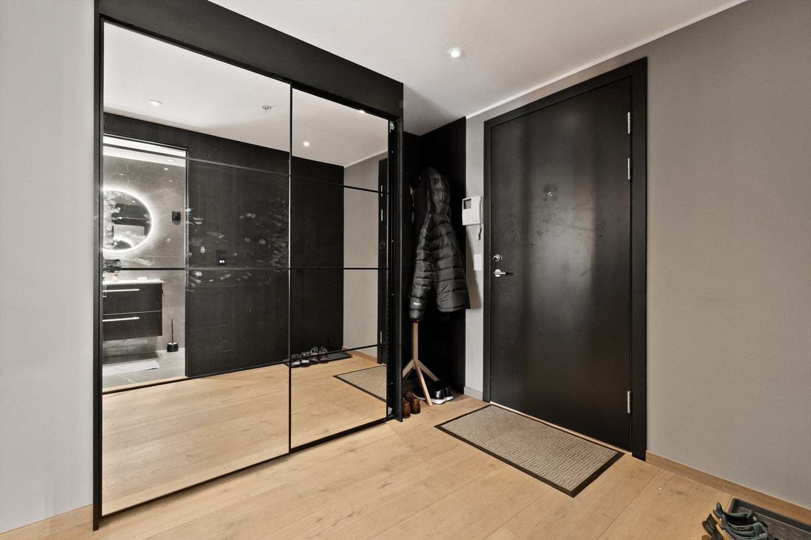 Velkommen inn i en innbydende entré med en stor skyvedørsgarderobe med speilfronter Galleribilde