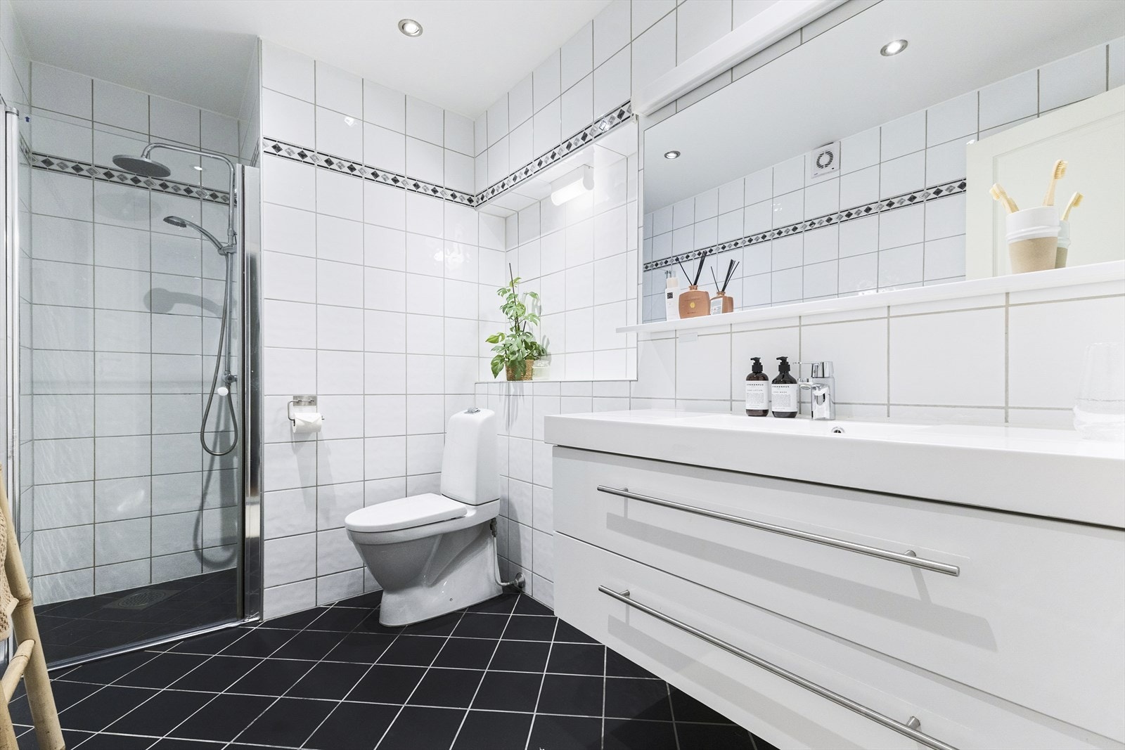 Badet i 1 etasje fremstår stilrent og funksjonelt, med en enkel og gjennomført utforming Galleribilde