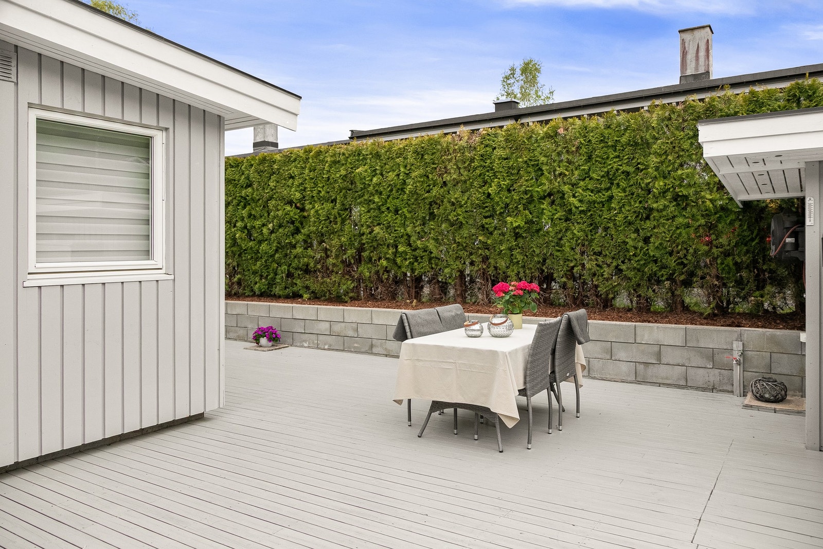 Huset har stor, fin terrasse og hekk som gir god skjerming Galleribilde