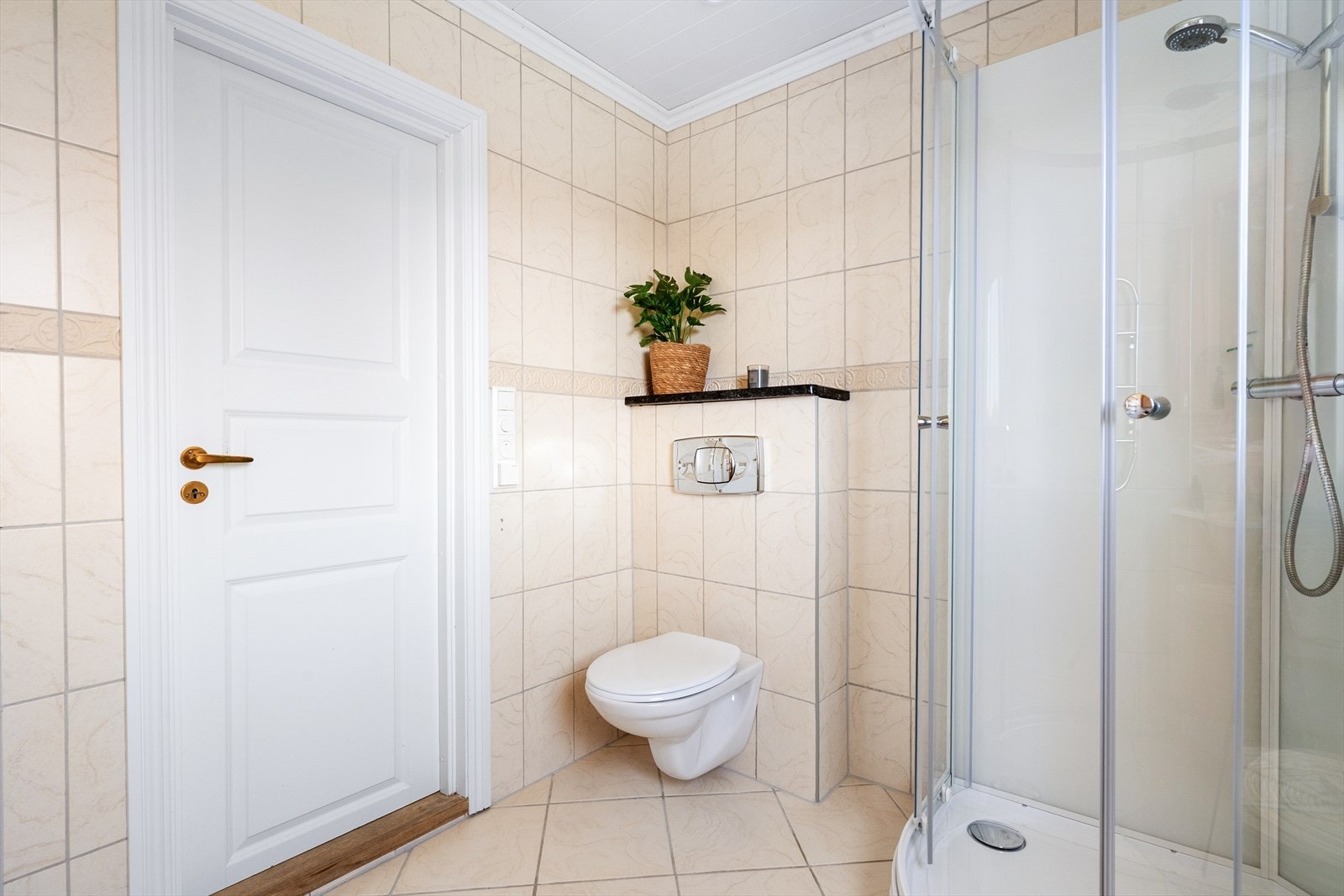 Badet er utstyrt med vegghengt toalett og dusjkabinett. Galleribilde