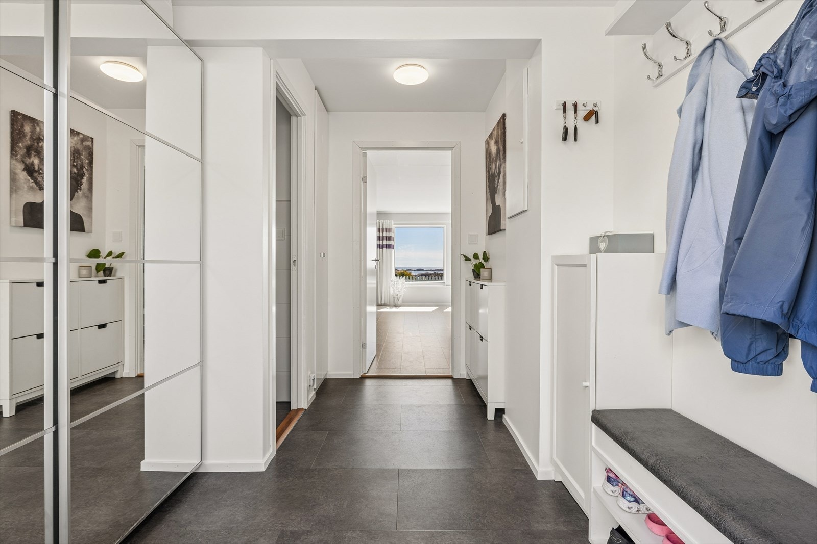 Entréen har gulvvarme og god plass til oppbevaring i skyvedørsgarderobe med speilfronter. Velkommen inn! Galleribilde