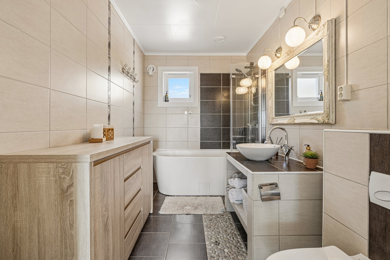 Badet er helfliset og utstyrt med både badekar og vegghengt toalett. Galleribilde