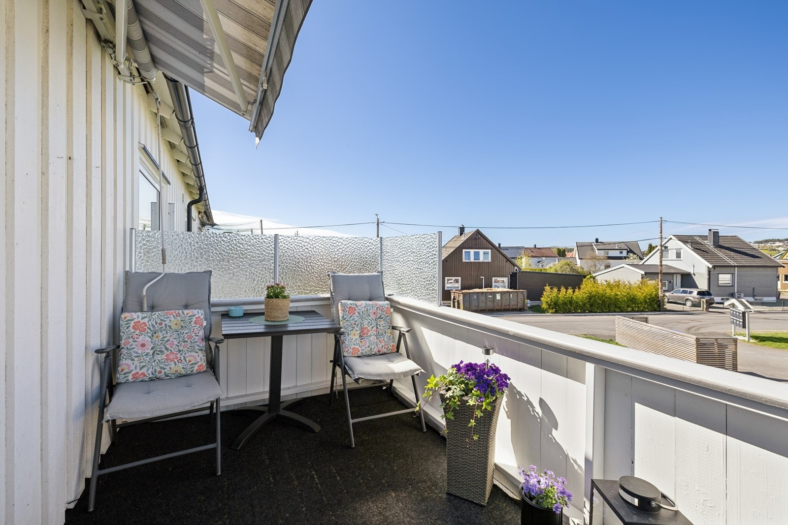 Plass til utemøbler og markiser som skjermer for solen en varm sommerdag. Galleribilde