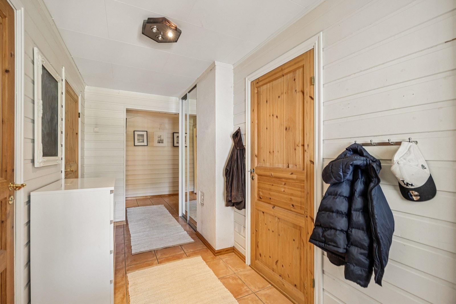 Entréen i sokkeletasjen har flislagt gulv med gulvvarme. Galleribilde