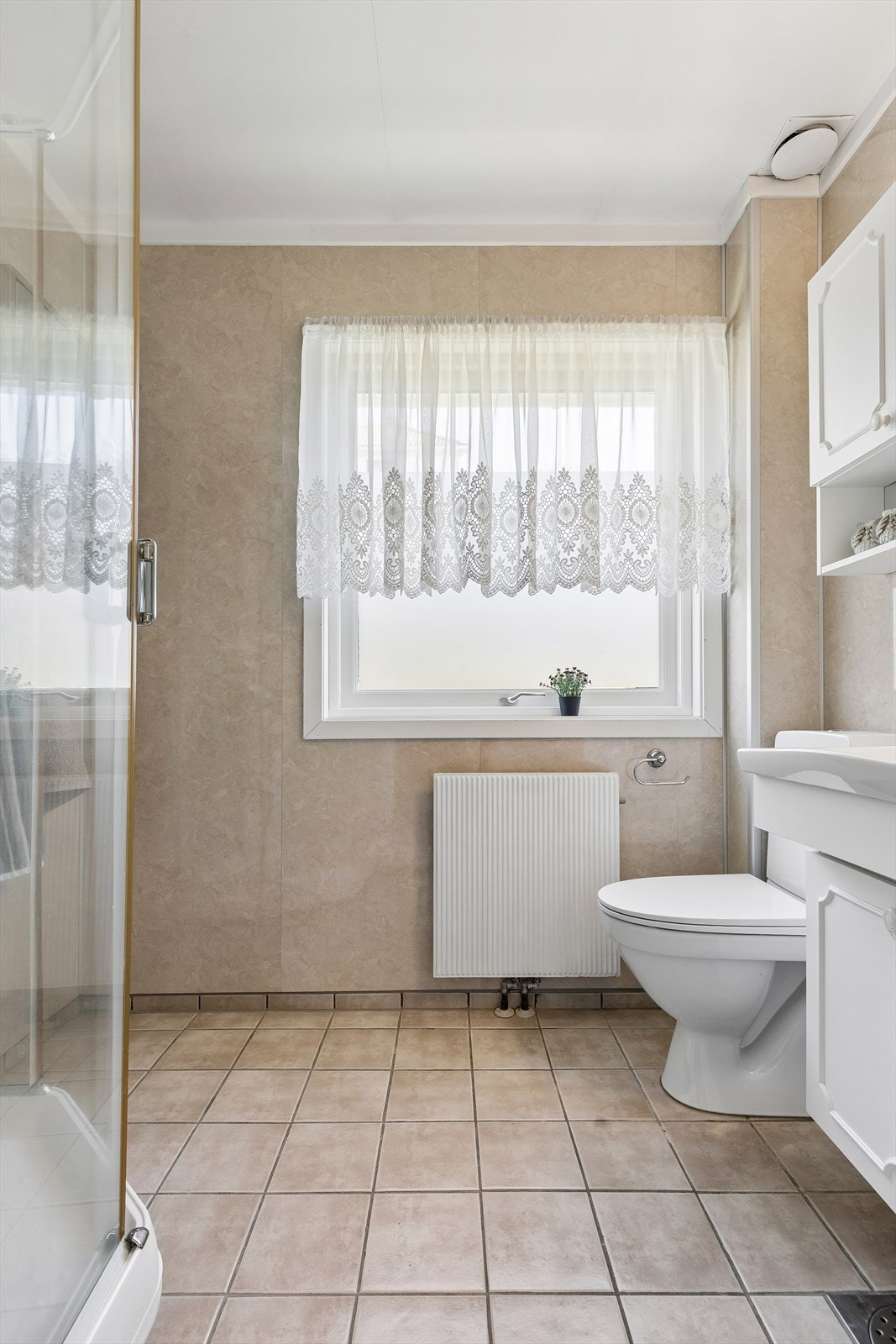 Badet er utstyrt med dusjkabinett, servantinnredning og toalett. Både toalett og dusjkabinett er skiftet ut de senere år. Galleribilde