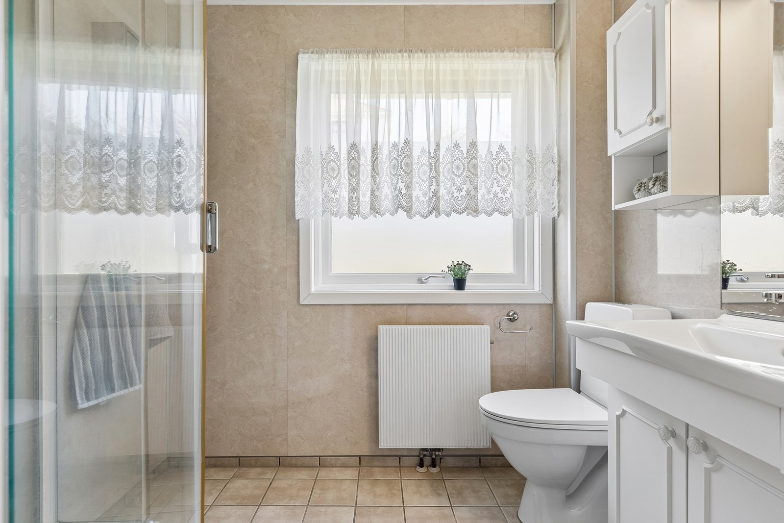 Badet er utstyrt med dusjkabinett, servantinnredning og toalett. Både toalett og dusjkabinett er skiftet ut senere år. Galleribilde