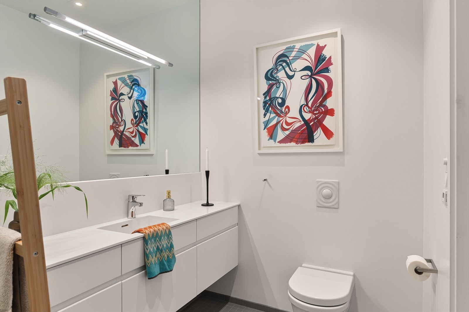 Badet har flislagt gulv med gulvvarme, vegghengt toalett og dusjhjørne. Galleribilde