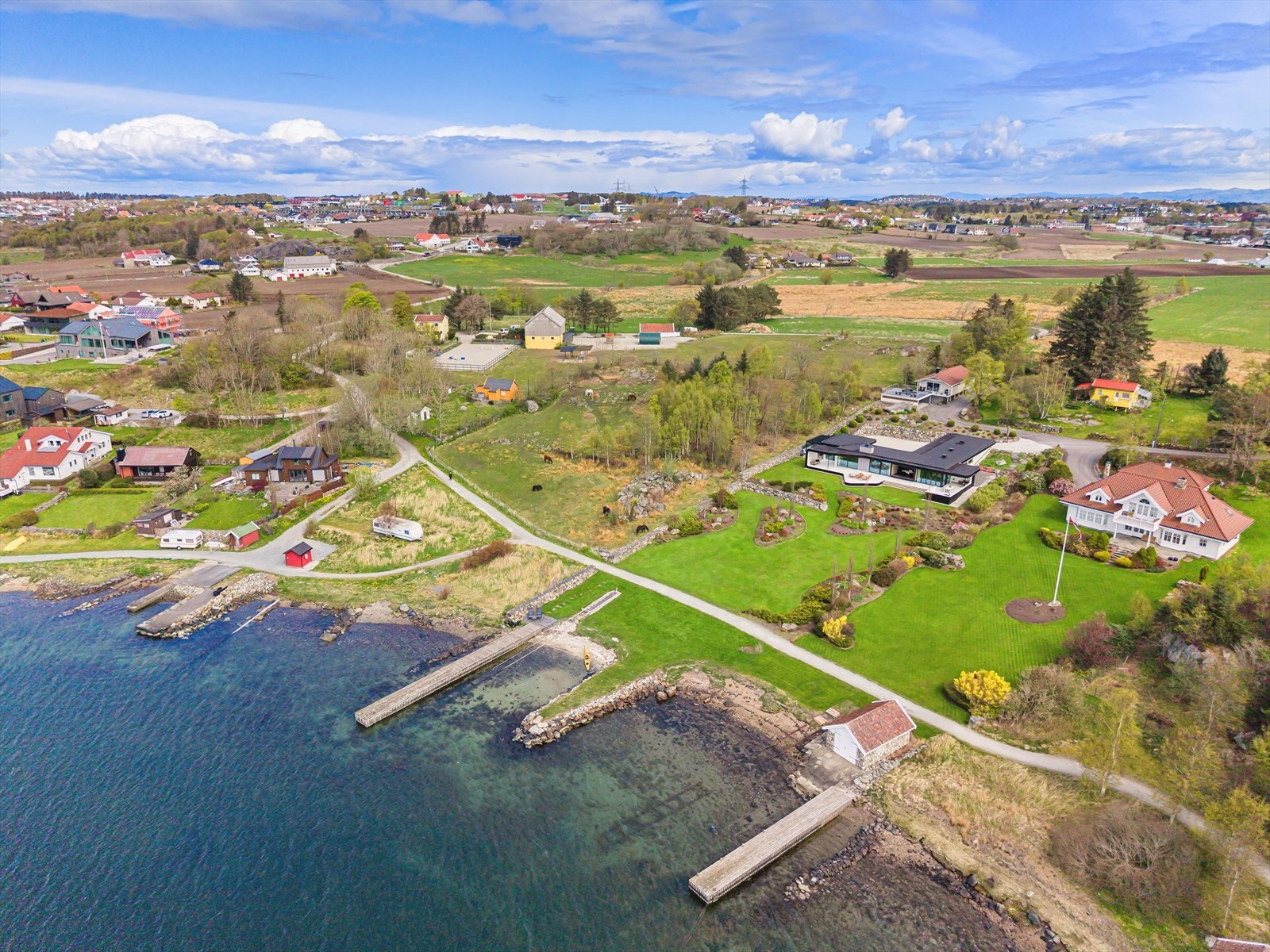 Tomten er parkmessig opparbeidet og byr på egen brygge, molo, strandlinje og båtopptrekk. Galleribilde