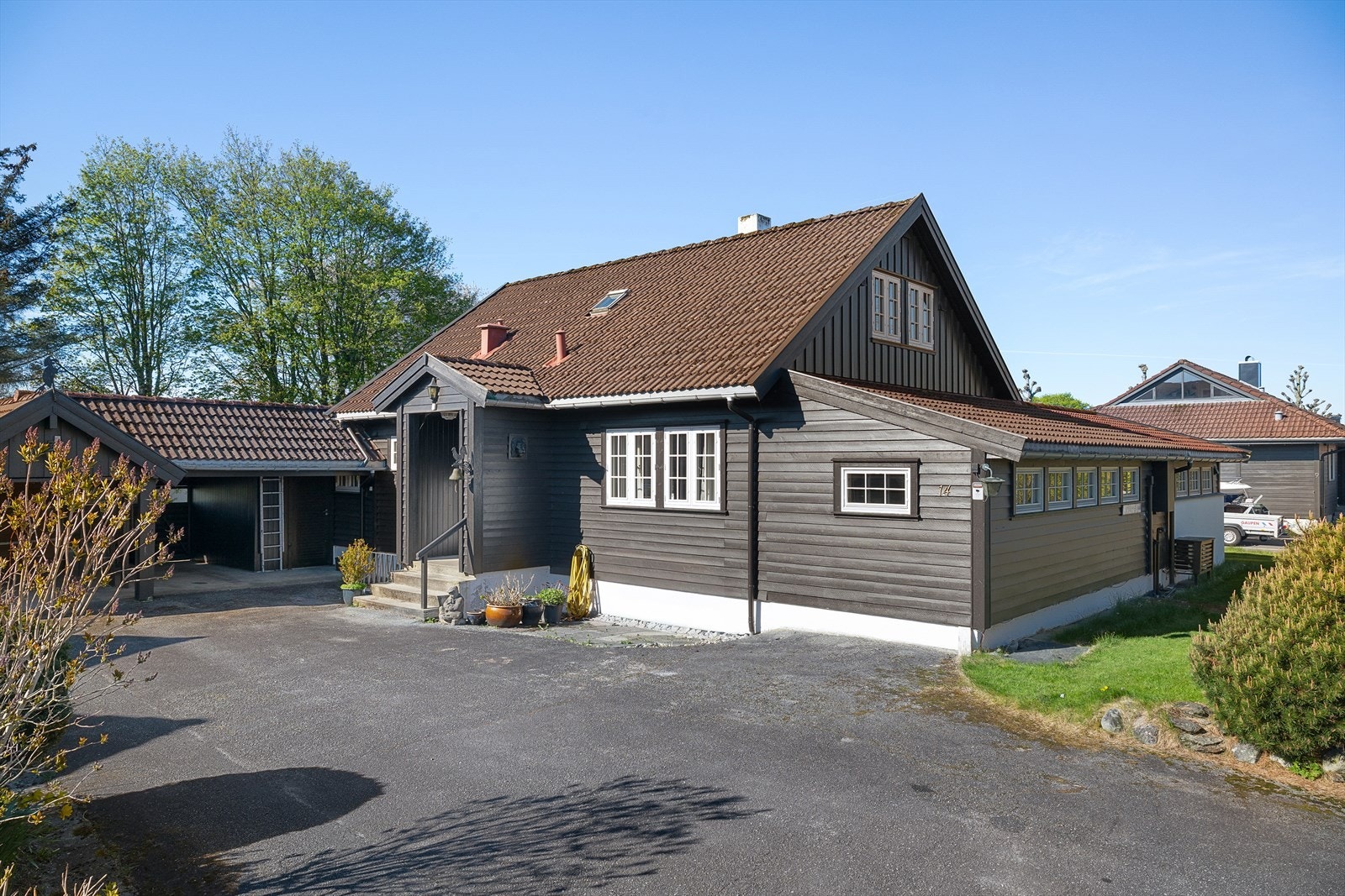 Eiendommen har romslig asfaltert gårdsrom med gode parkeringsmuligheter. I tillegg er det dobbel carport, med elbillader. Galleribilde
