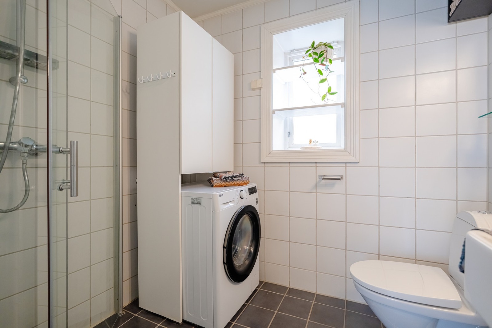 Badet er lyst, flislagt med gulvvarme og downlights i himling. Det er opplegg for vaskemaskin. Galleribilde