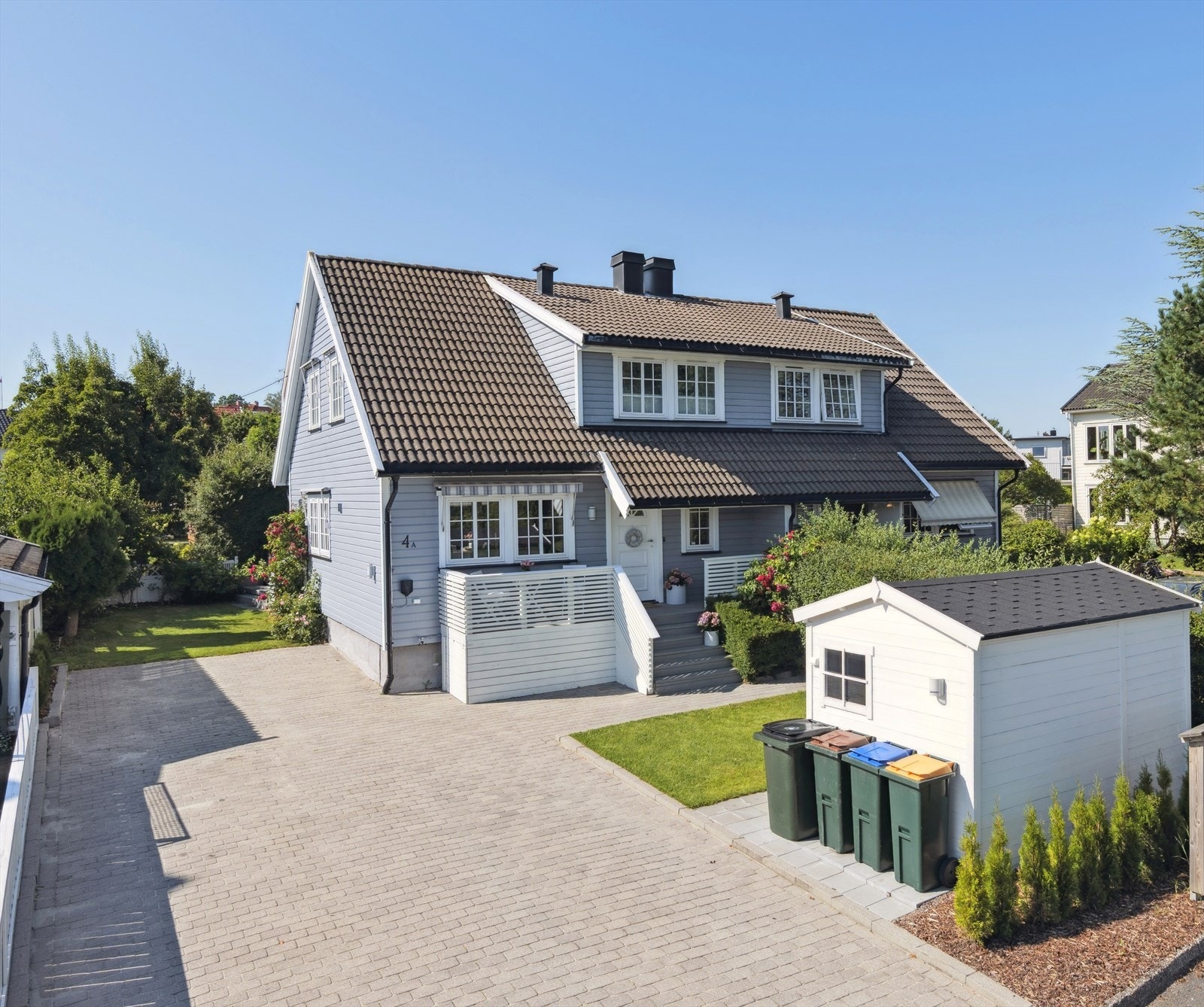 Gårdsplassen har god plass til parkering av flere biler. Montert elbillader på husveggen. Galleribilde