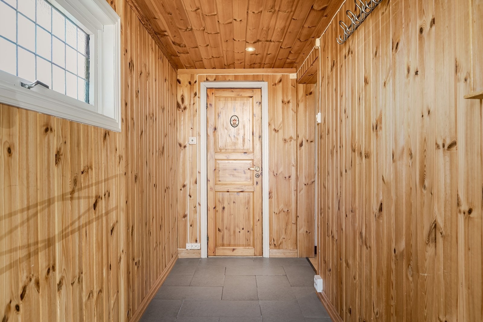 I entréen er det plass til å kunne henge fra seg ytterjakka. Det er direkte adkomst til badet herfra og videre inn til gang. Galleribilde