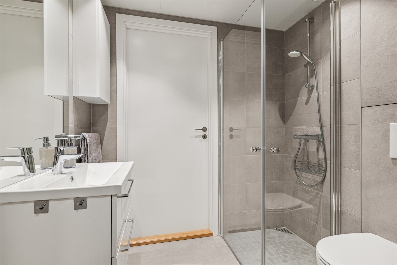 Pent flislagt bad med varmekabler. Badet har inngang fra entrèen. Galleribilde