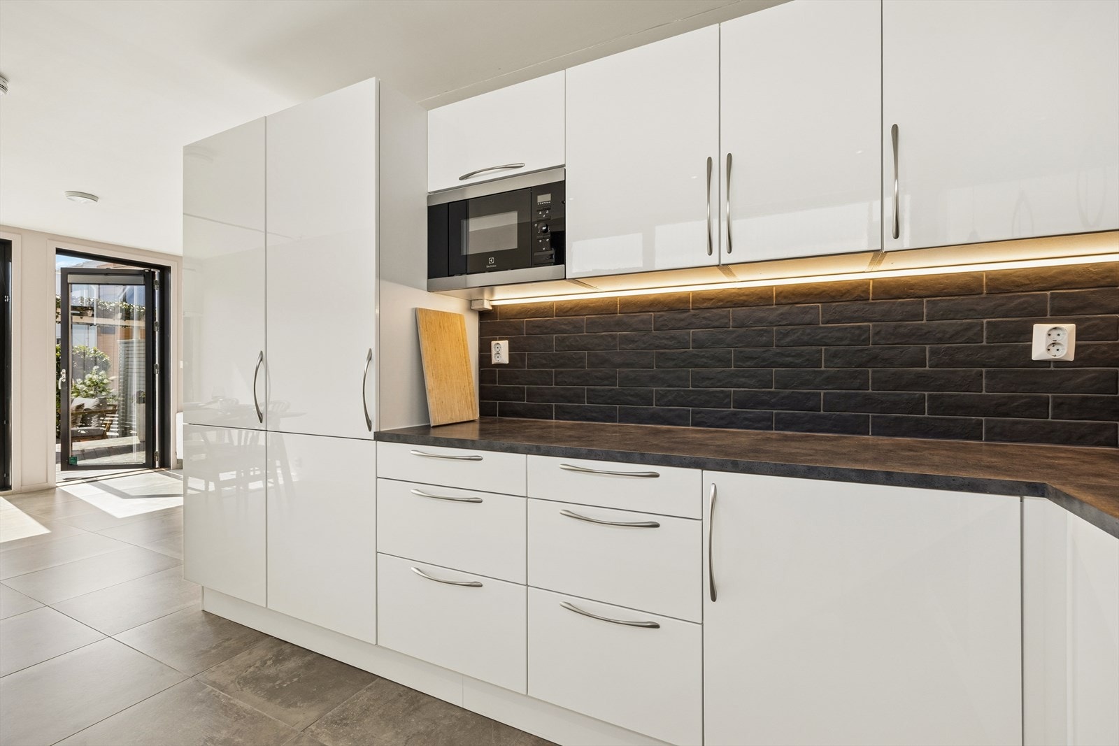 Her er det godt med både skap- og benkeplass. Kjøkkenet ligger i moderne løsning sammen med stuen. Det kan også nevnes at man har et helt kjøleskap og ett helt fryseskap for ekstra god oppbevaring. Galleribilde