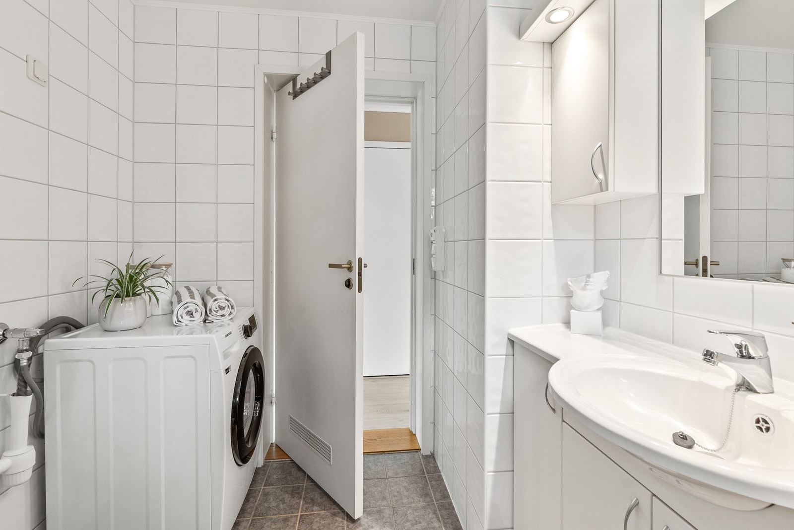 Badet har lys baderomsinnredning og opplegg for vaskemaskin. Galleribilde