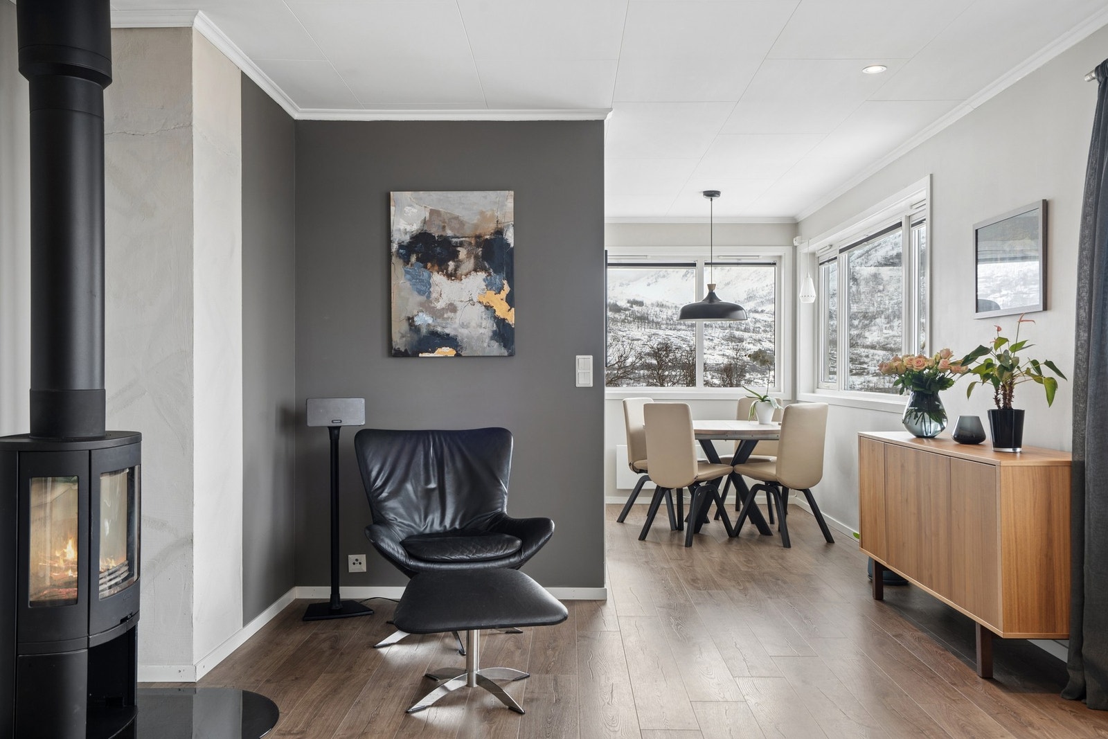 En moderne vedovn er et sentralt element i stuen, og gir både effektiv varme og en hyggelig atmosfære. Galleribilde