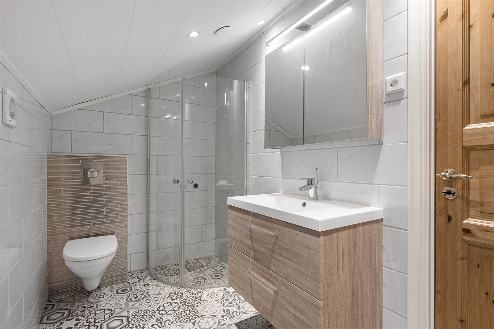 Badet i boenheten har flislagt gulv med varmekabler, dusjnisje og vegghengt toalett. (Ikke godkjent for varig opphold se pkt med ferdigattest i salgsoppgaven) Galleribilde