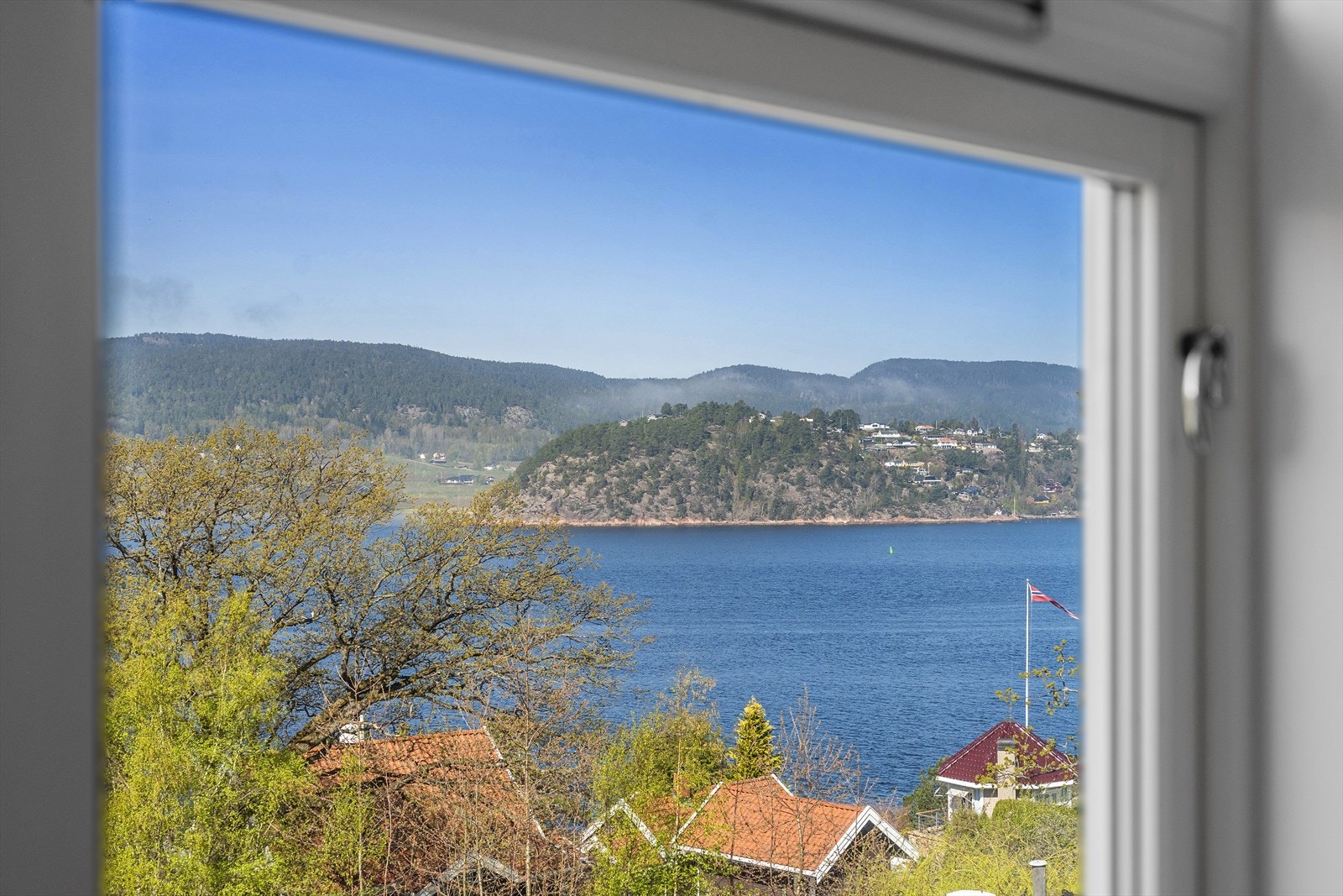 Utsikt fra stuen mot fjorden og det grønne landskapet. Galleribilde
