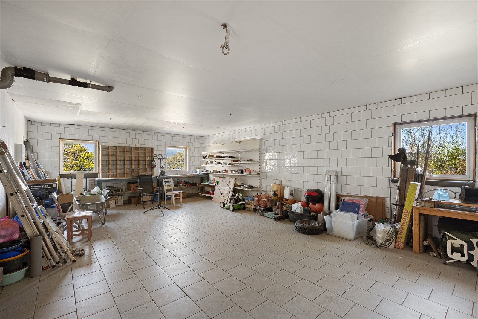 Stor garasje med gulv av industrikvalitetsflis. Rikelig med plass til verksted, hobbyaktiviteter og lagring. Galleribilde