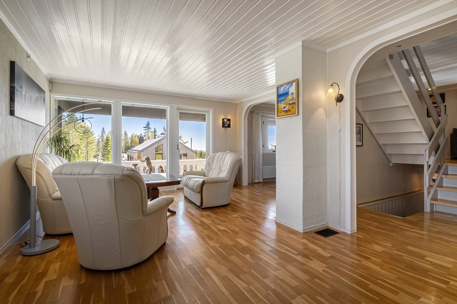 En åpen buegang og den malte tretrapper binder etasjene sammen på en elegant måte. Galleribilde