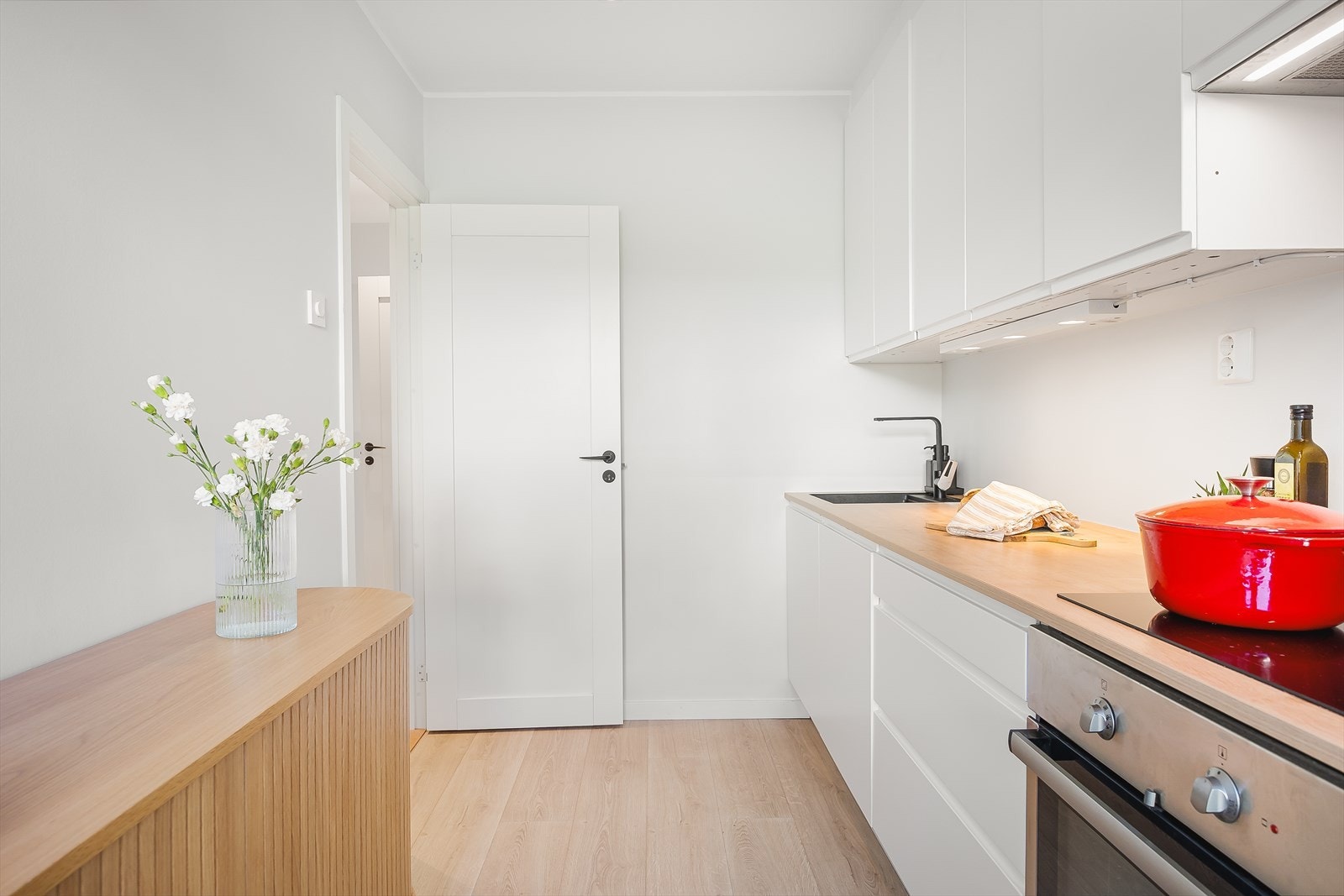 Kjøkken med innredning bestående av slette fronter og laminat benkeplate, samt kompositt vask med beslag. Galleribilde