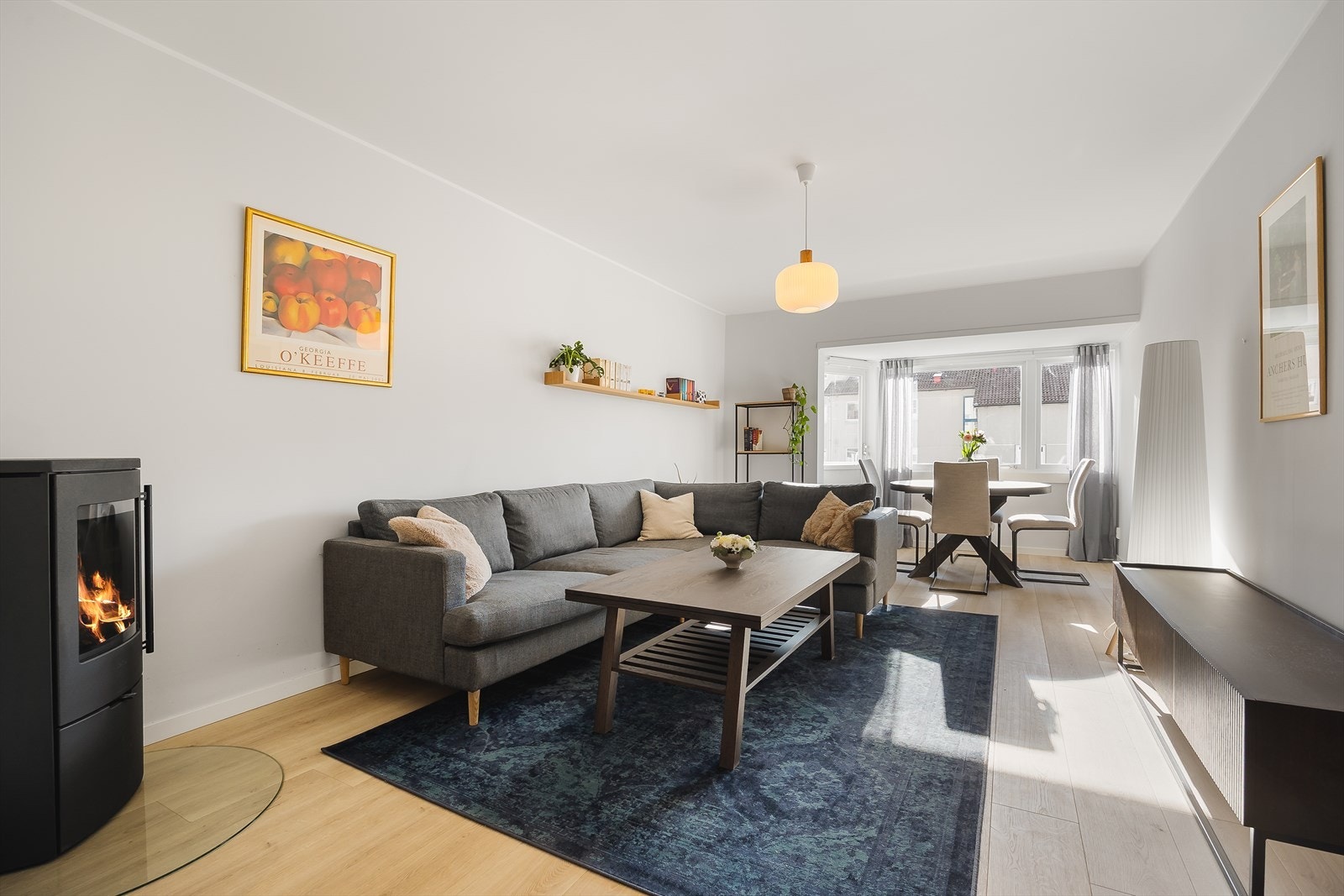 Stuen er av god størrelse med vedovn, fine overflater og god plass til både sofa og spisebord Galleribilde