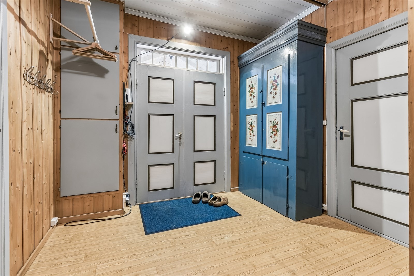 Entréen har vegger kledd med trepanel og gir tilgang til flere av boligens rom. Galleribilde