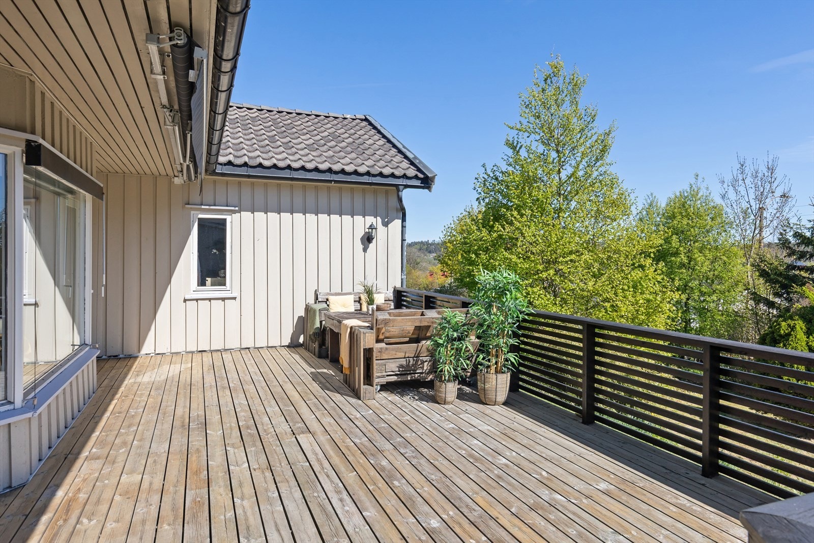 Fra stuen er det utgang til romslig terrasse. Markise. Trapp ned til hage. Galleribilde