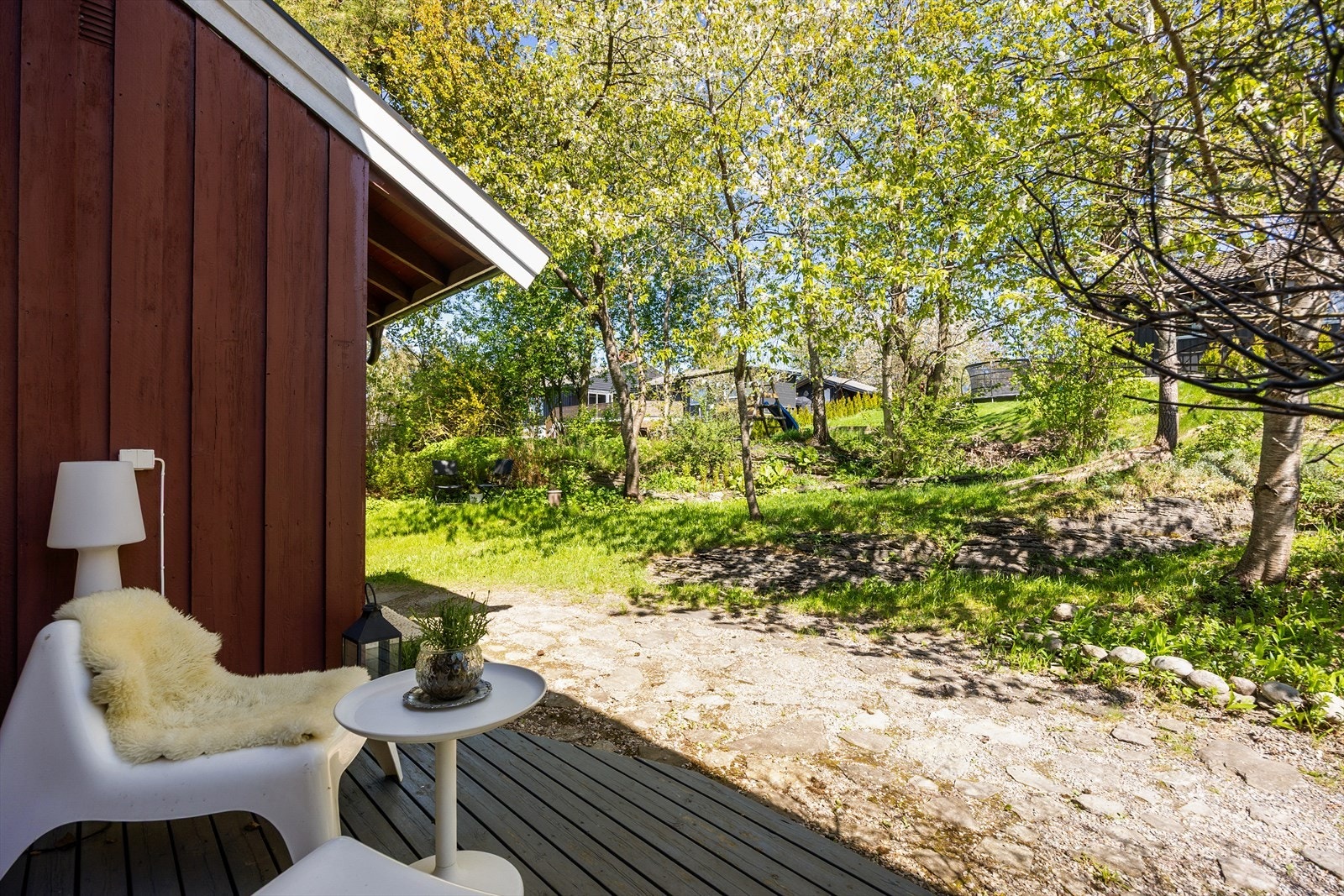 Uteområde med gressplen og beplantning som skaper en grønn og frodig ramme rundt boligen. Galleribilde