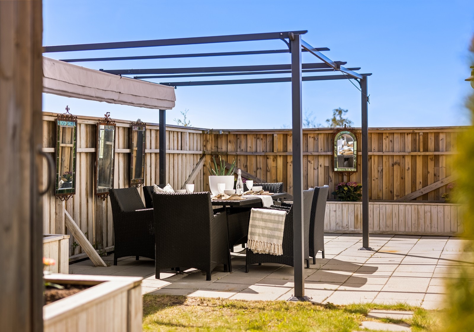 En usjenert uteplass med pergola gir en fin ramme for utendørs måltider. Galleribilde