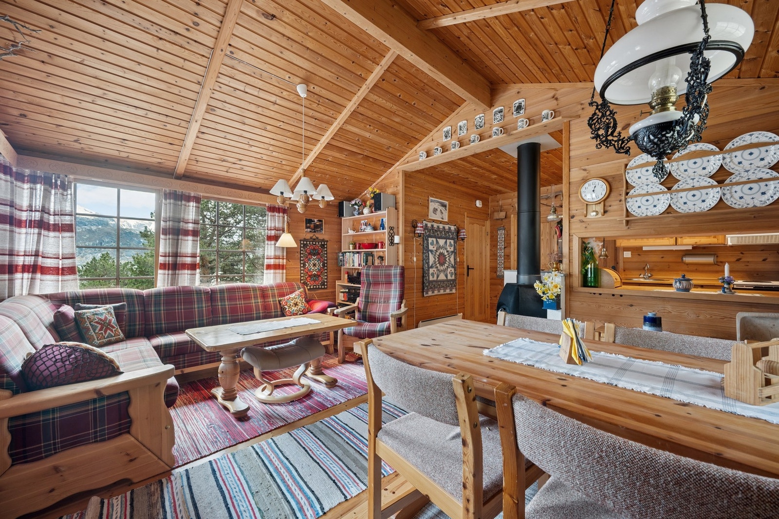 Stuen har en klassisk hyttestil med furugulv og panel på vegger og tak. Galleribilde