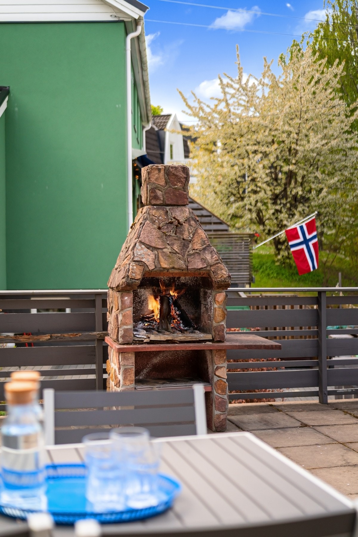 Felles-takterrassen over garasjen har hellelagt dekke, murt utepeis og rekkverk i tre. Galleribilde