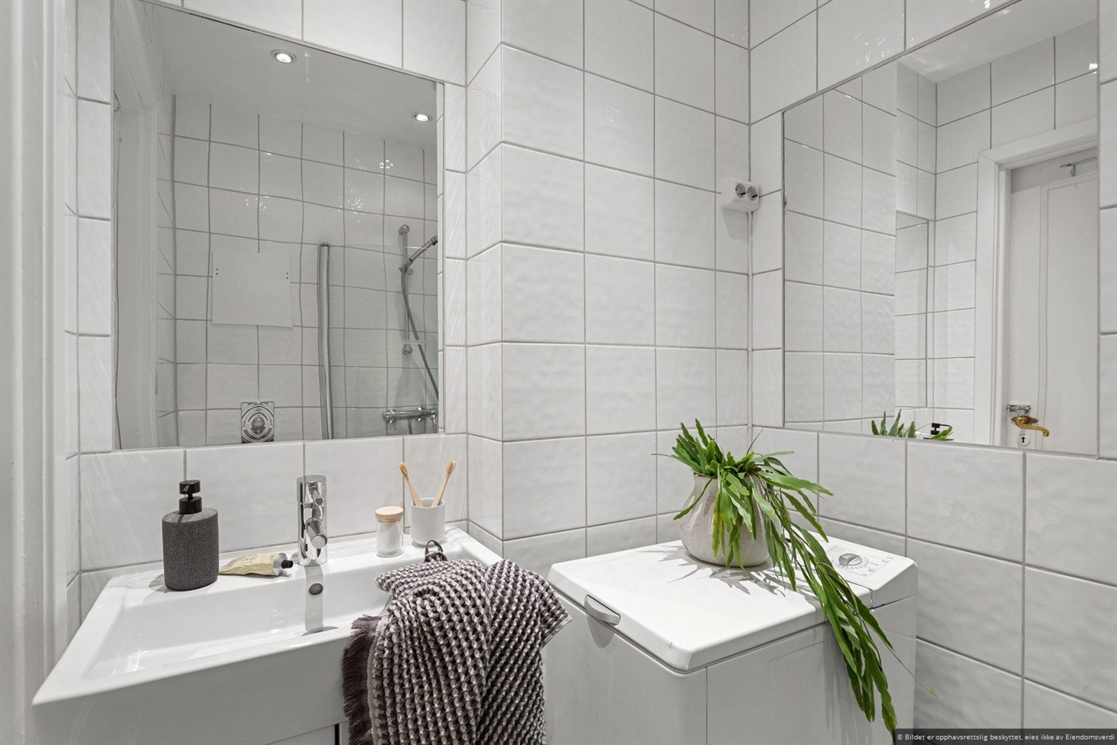 Pent flislagt baderom med vaskemaskin. Galleribilde