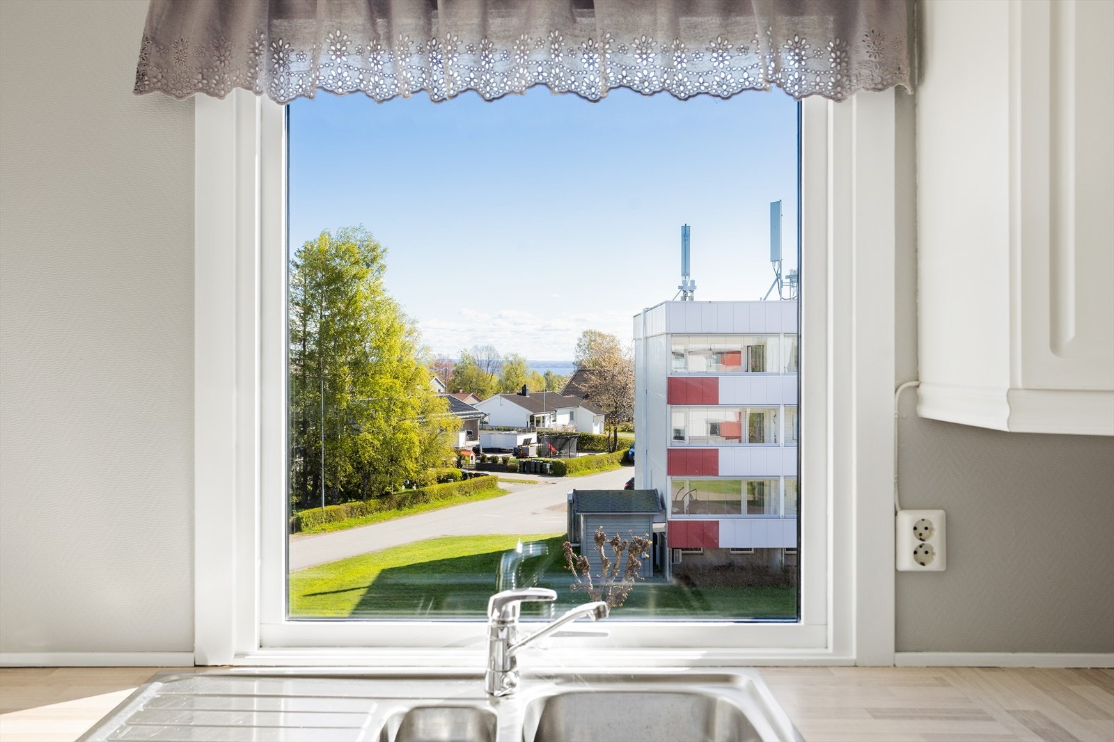 Fra kjøkkenvinduet har man utsikt over nærområdet og et glimt av fjorden. Galleribilde