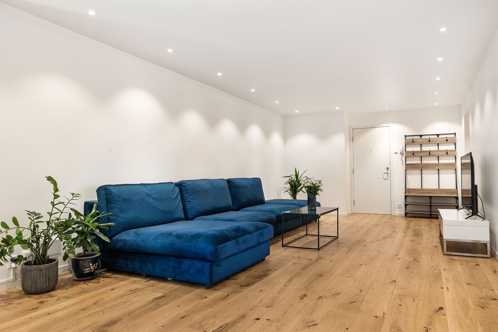 Stuen fremstår som moderne og gjennomført med tidsriktige overflater, downlights og gode møbleringsmuligheter. Galleribilde
