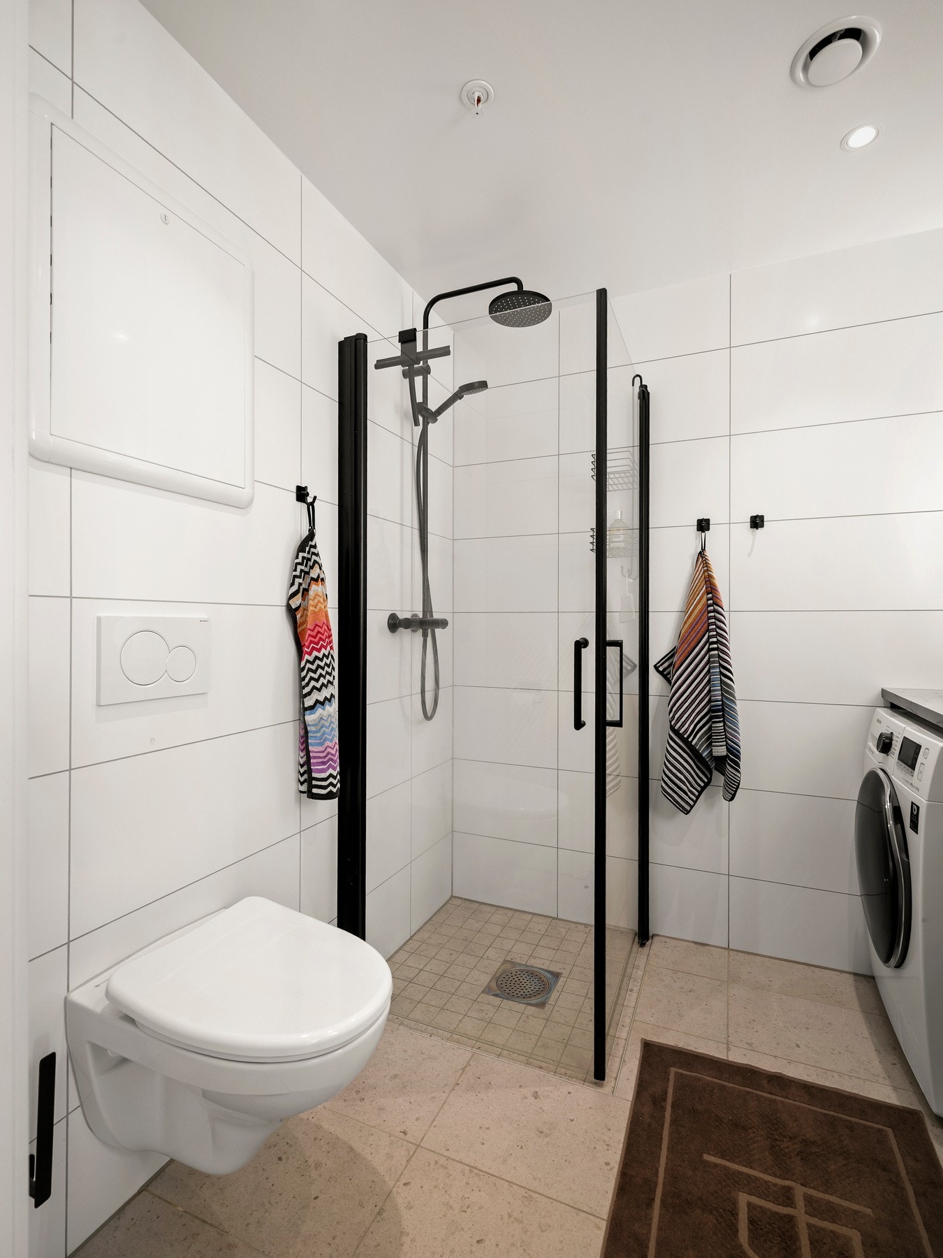 Badet består av vegghengt klosett, dusjhjørne, servant med skuffer og speil med belysning. Opplegg for vaskemaskin og tørketrommel. Galleribilde
