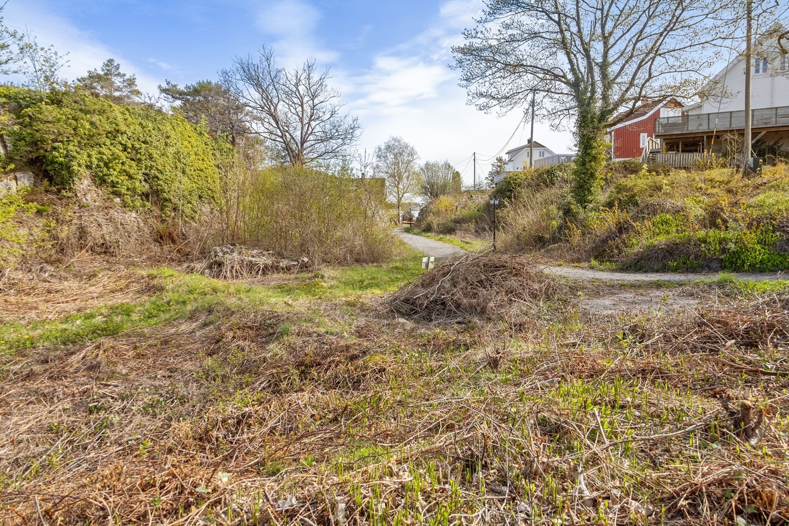 På tomtens laveste parti finnes et flatt og fint område med gode muligheter for å etablere en nydelig sørlandshage eller plen. Galleribilde