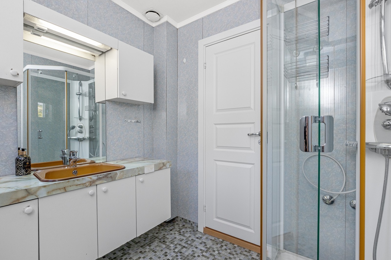 Badet er utstyrt med servant med innredning, dusjkabinett og varmekabler i gulvet. Galleribilde