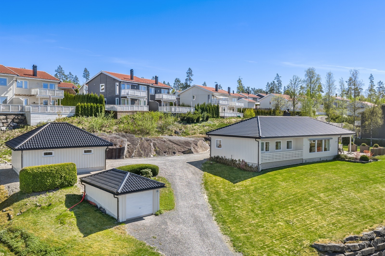 Oversikt over eiendommen som viser boligen og de to garasjebyggene. Galleribilde