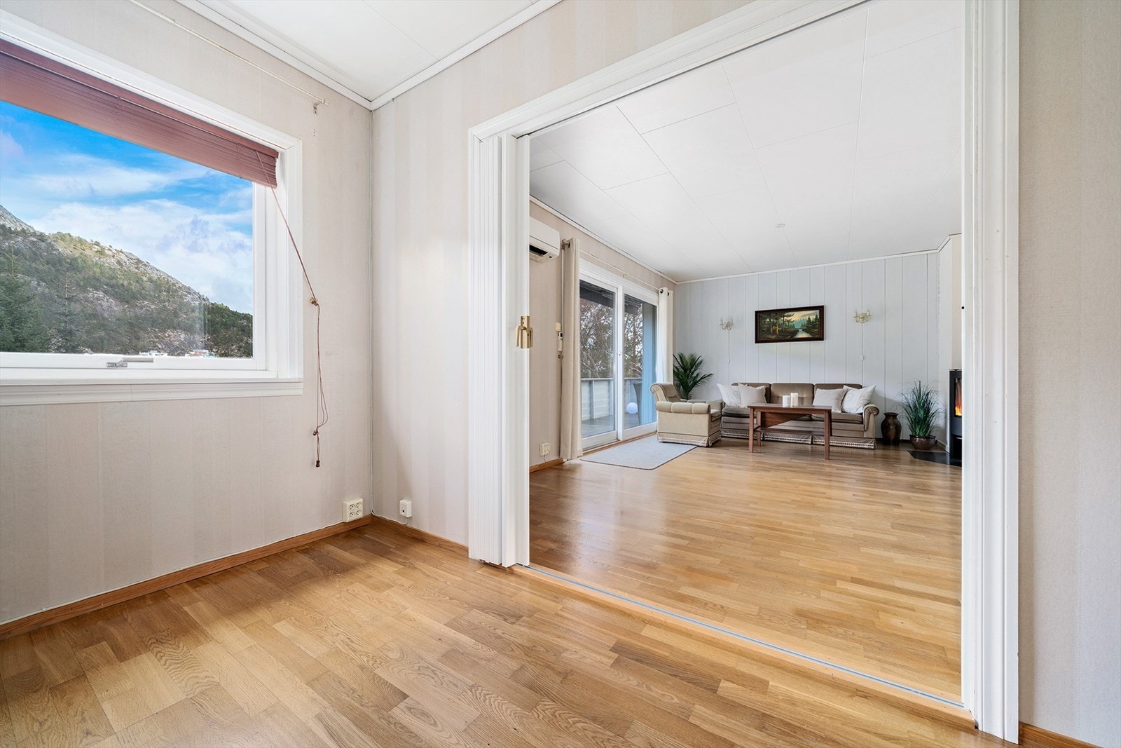 Rommet har en praktisk skyvedør mot stuen, som gir en fin flyt mellom sonene og gjør det enkelt å åpne opp eller skjerme av etter behov. Galleribilde