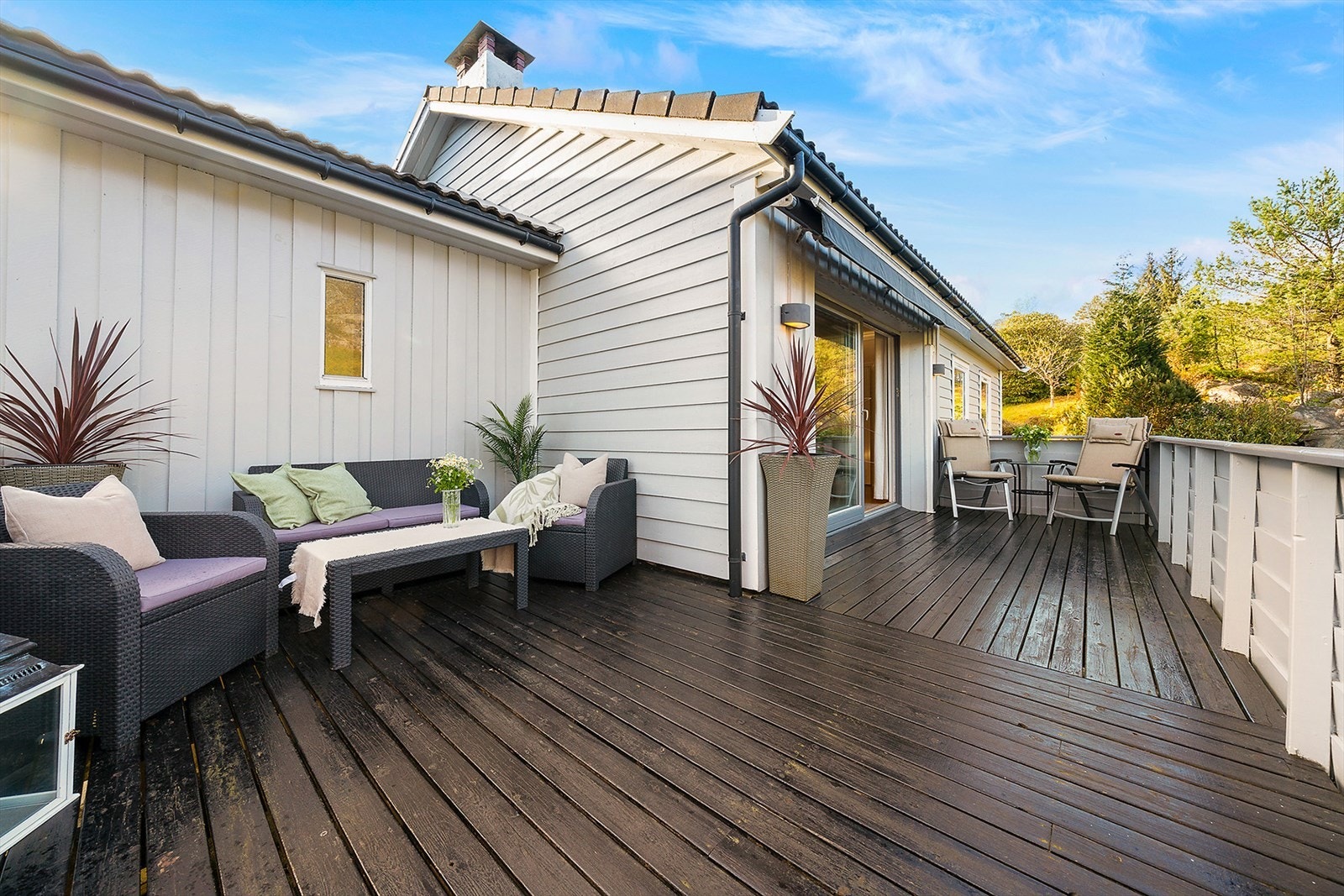 Stor terrasse med plass til flere sittegrupper, perfekt for både avslapning, grilling og sosiale sammenkomster gjennom hele sesongen. Galleribilde