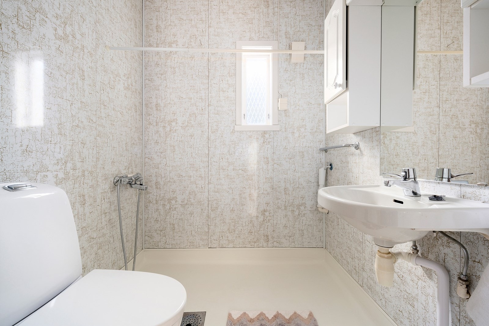 Vegg i vegg med hovedbadet har boligen et mindre og enkelt bad, som gir en svært praktisk løsning for barnefamilier og bidrar til en smidig hverdag på travle morgener. Galleribilde