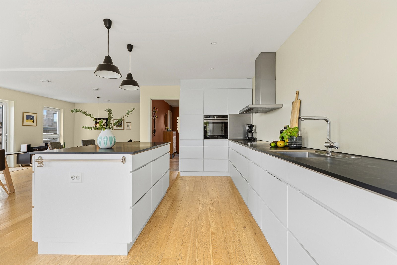 Romslig kjøkken med kjøkkenøy, integrerte hvitevarer og rikelig med oppbevaringsplass i skap og skuffer Galleribilde