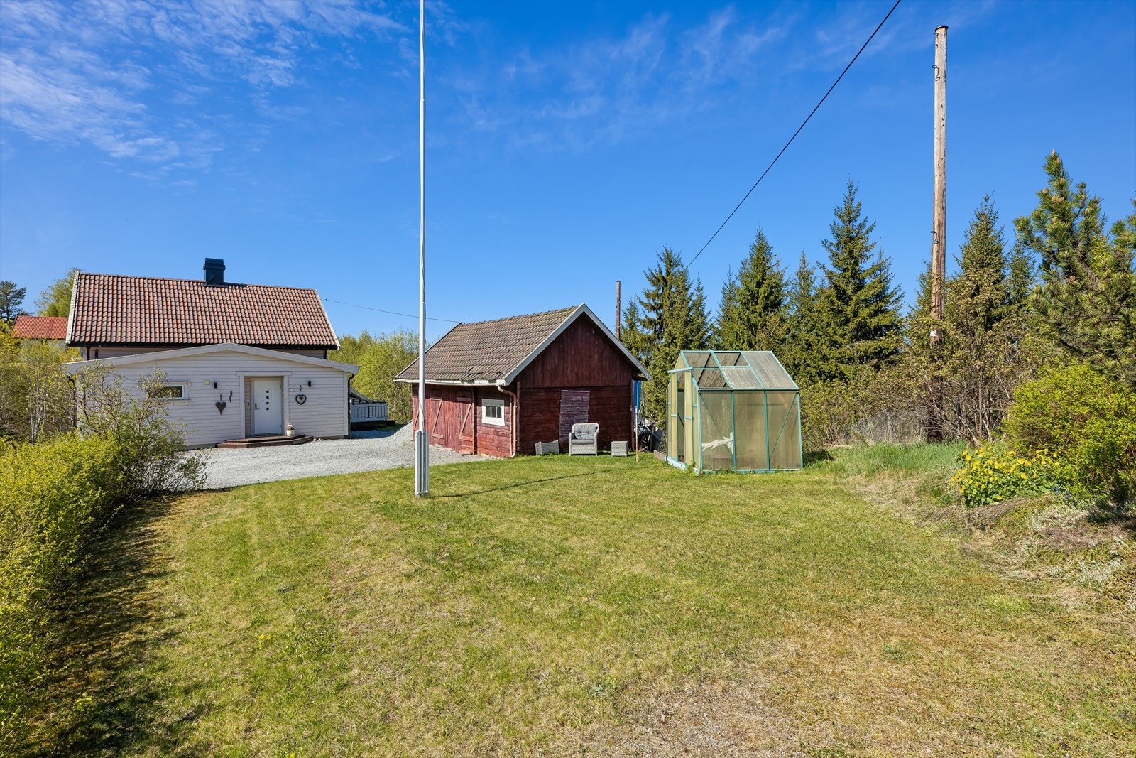 Tomten er opparbeidet med gruslagt gårdsplass og plenarealer. Galleribilde