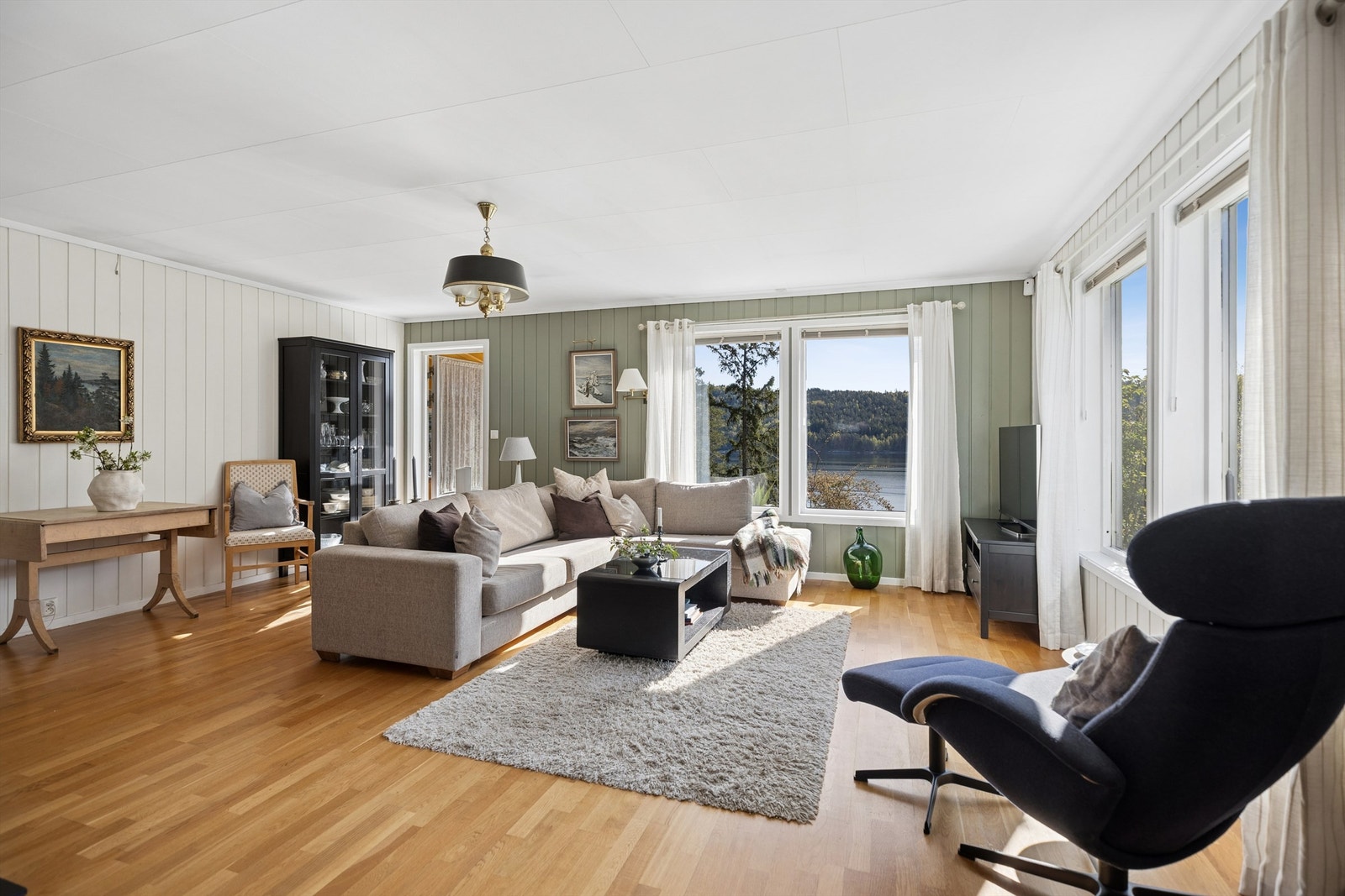 Lys og innbydende stue med store vindusflater som slipper inn rikelig med naturlig lys. Galleribilde
